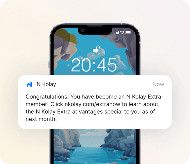 Smartphone showing an N Kolay push notification: "Congratulations! You have become an N Kolay Extra member!" followed by a link to learn about membership advantages.