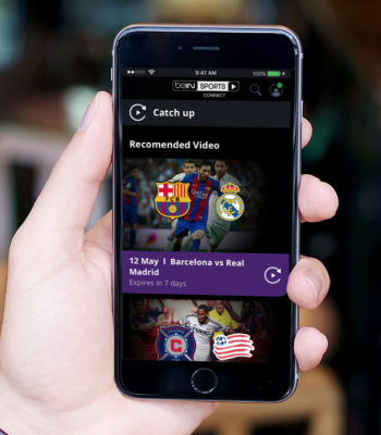 A hand holds a smartphone displaying the "beIN SPORTS CONNECT" app. The screen shows a "Catch up" section with recommended soccer videos, specifically a Barcelona vs. Real Madrid match highlight.